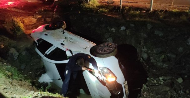 Dereye devrilen otomobil sürücüsü çevredekilerin yaradımı ile sıkıştığı yerden çıktı
